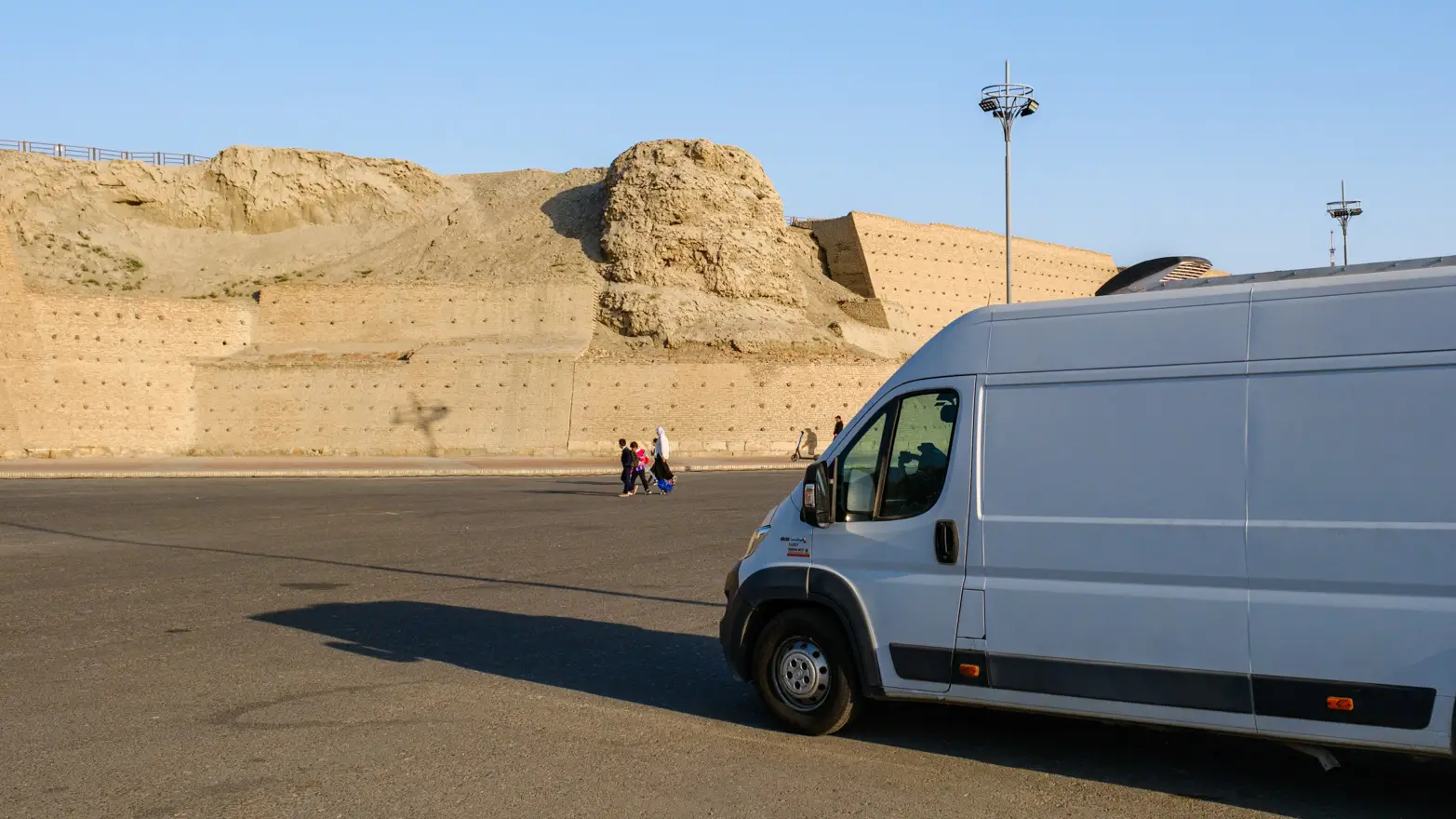 dodávka na parkovišti s hradbami v pozadí