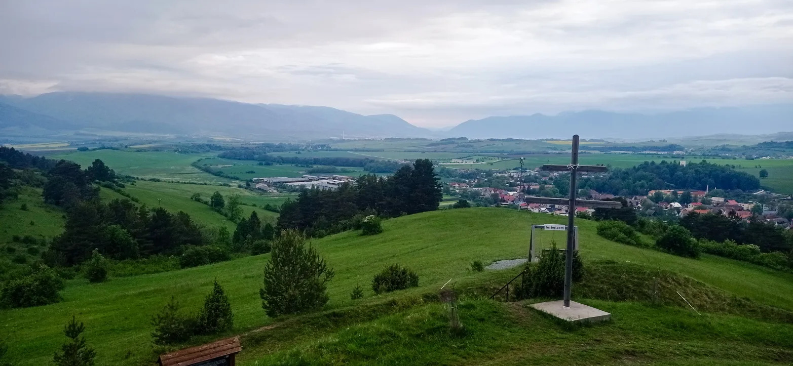 výhled na zelenou krajina s dřevěným křížem v popředí