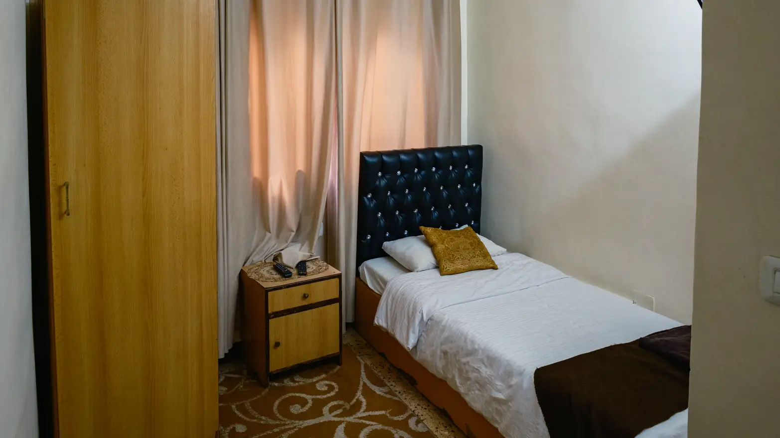 postel a skříň v malém pokoji