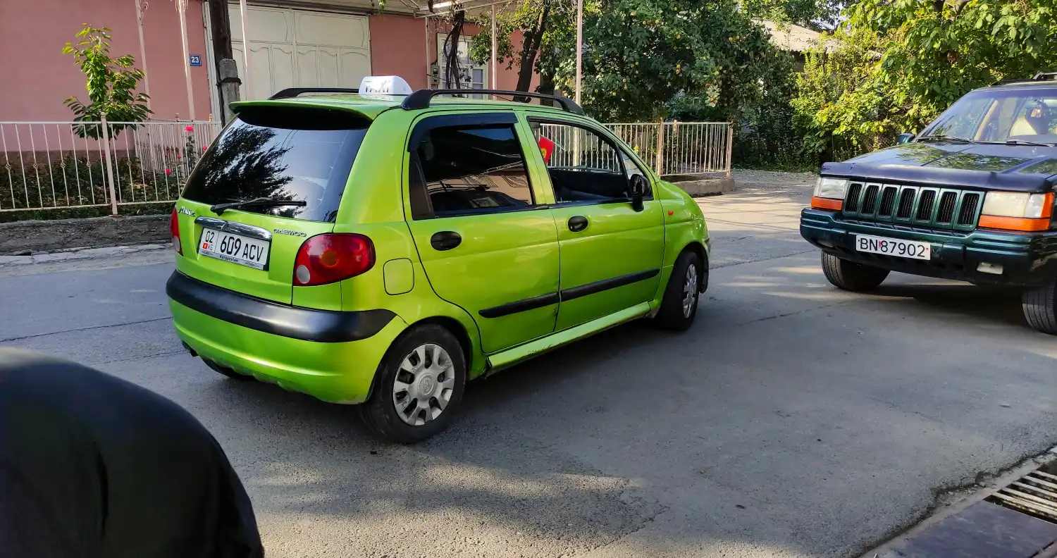 malé zelené auto s cedulí taxi