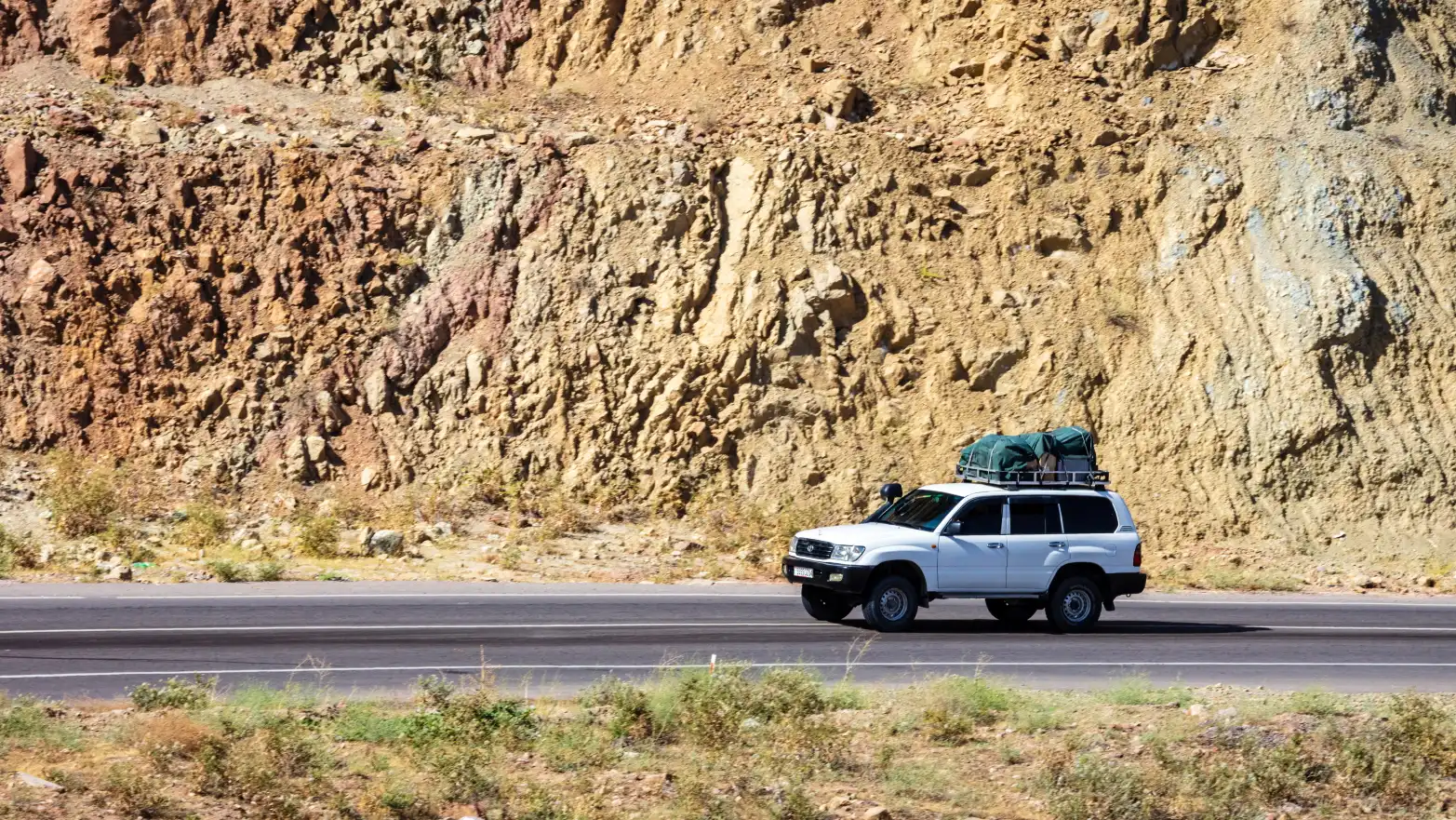 bíla Toyota Land Cruiser s zelenou bagáží na střeše