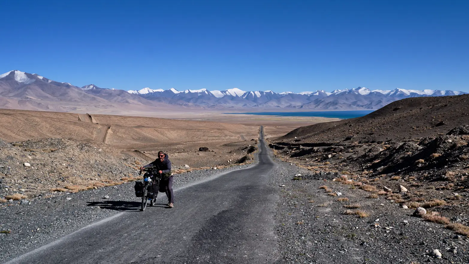 cyklista tlačící kolo do svahu