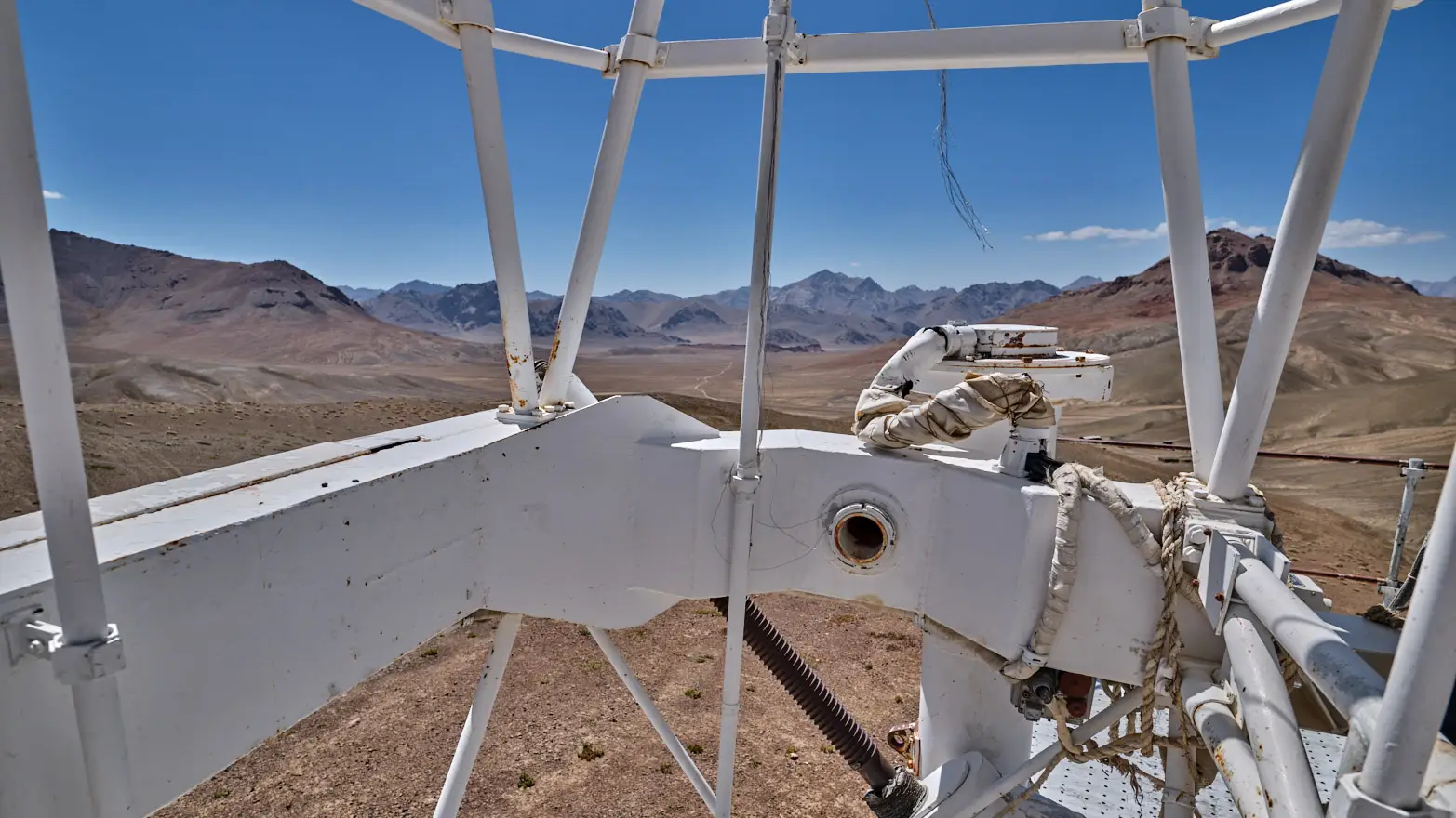výhled na horskou krajinu skrze bílé trubky hvězdářského zařízení