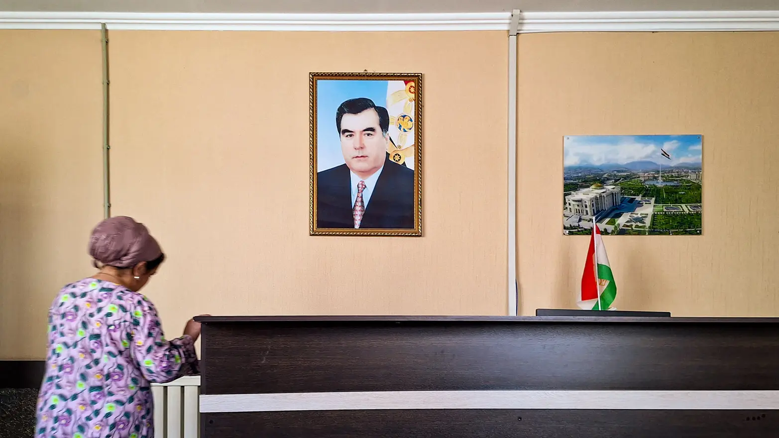 portrét na stěně za recepčním pultem