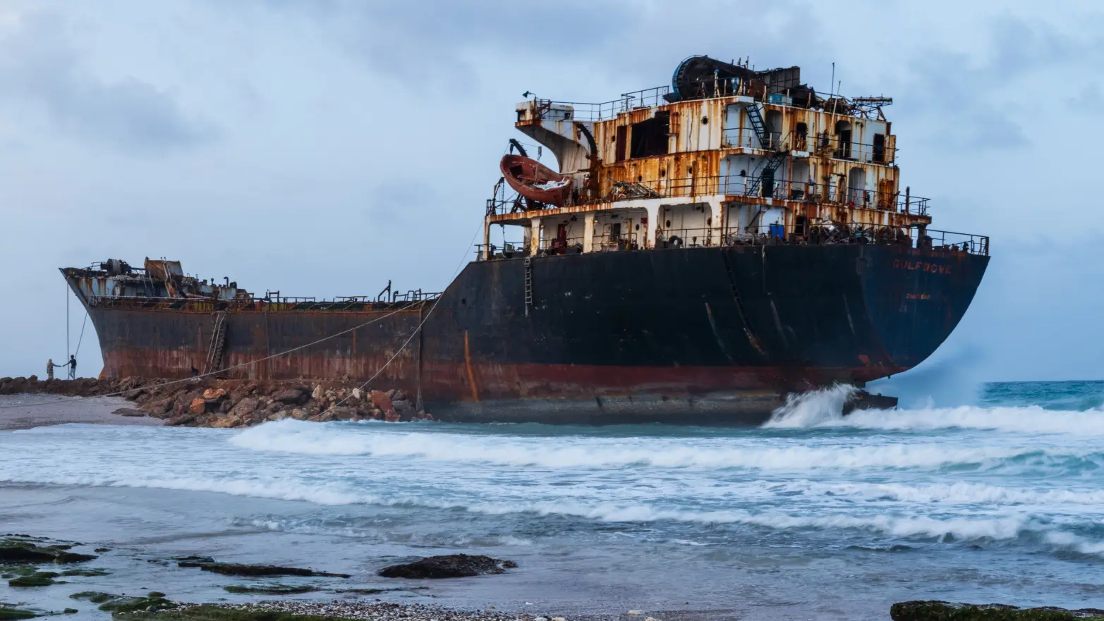 prorezlý, ztroskotalý tanker na pláží