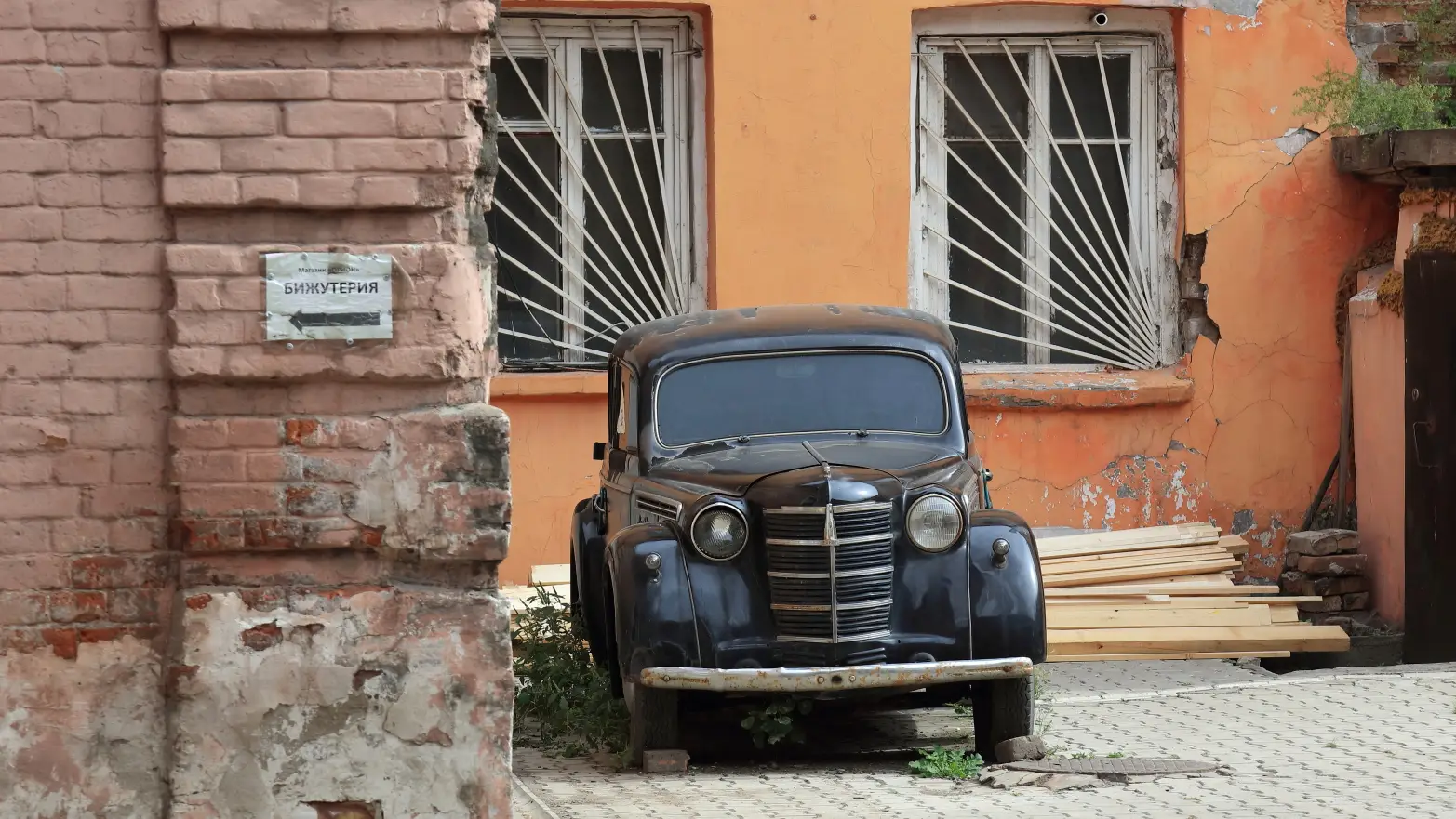 staré černé auto zaparkované ve dvoře