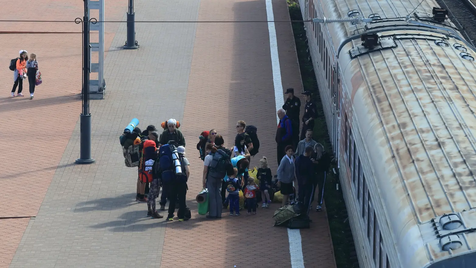hlouček cestujících před vlakem