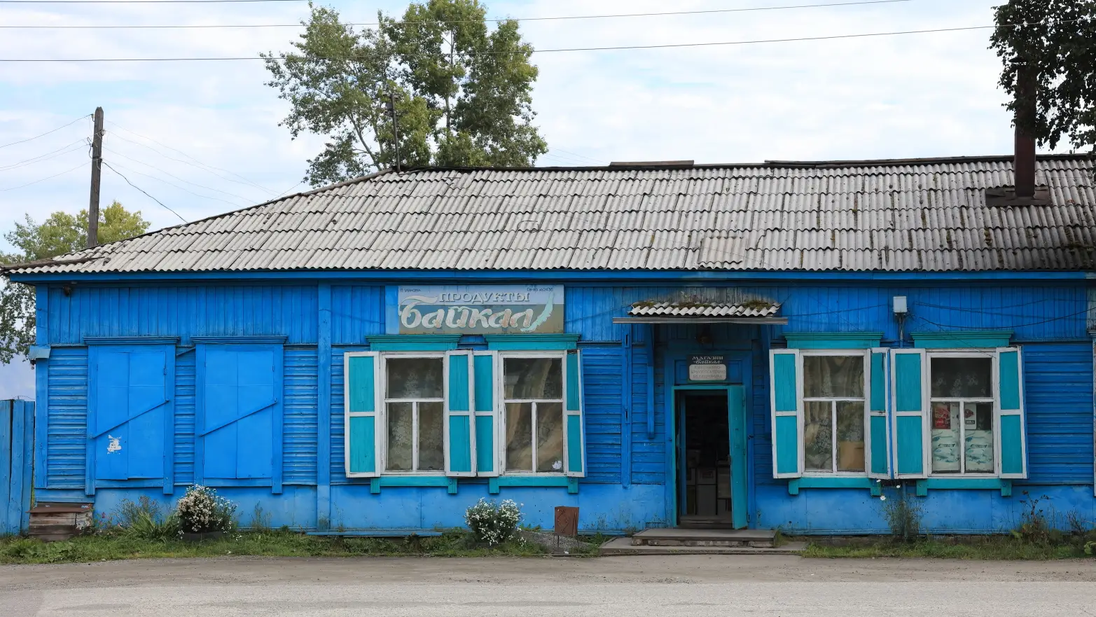 modře natřená dřevěná budova s bílými okenicemi