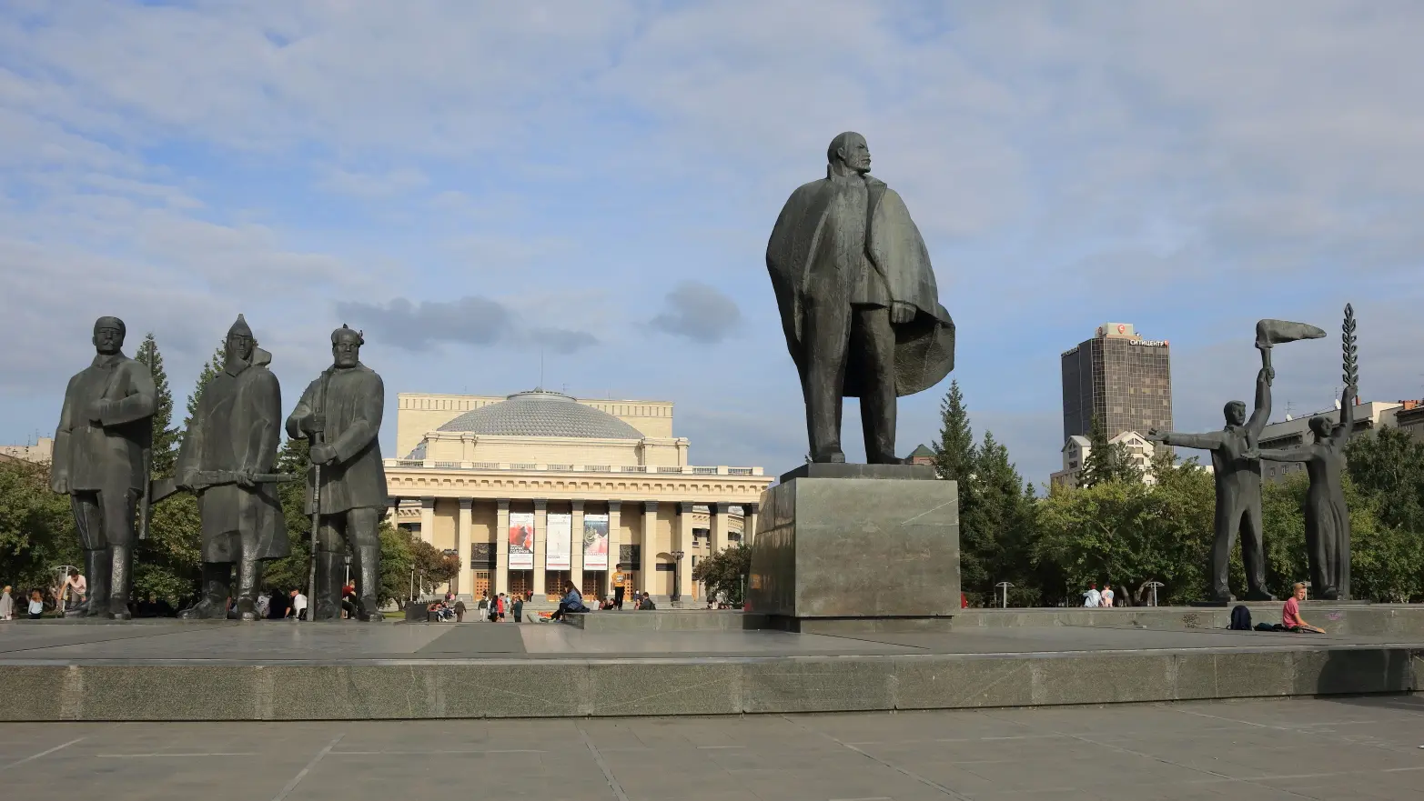 socha Lenina s velkou kopulovitou stavbou v pozadí